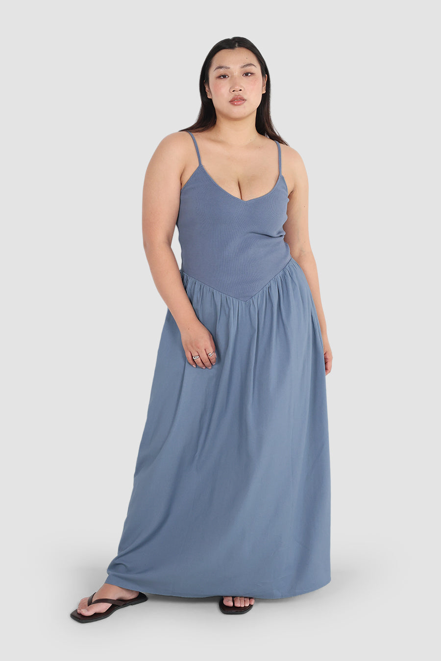 Woman wearing a blue maxi dress on a white background